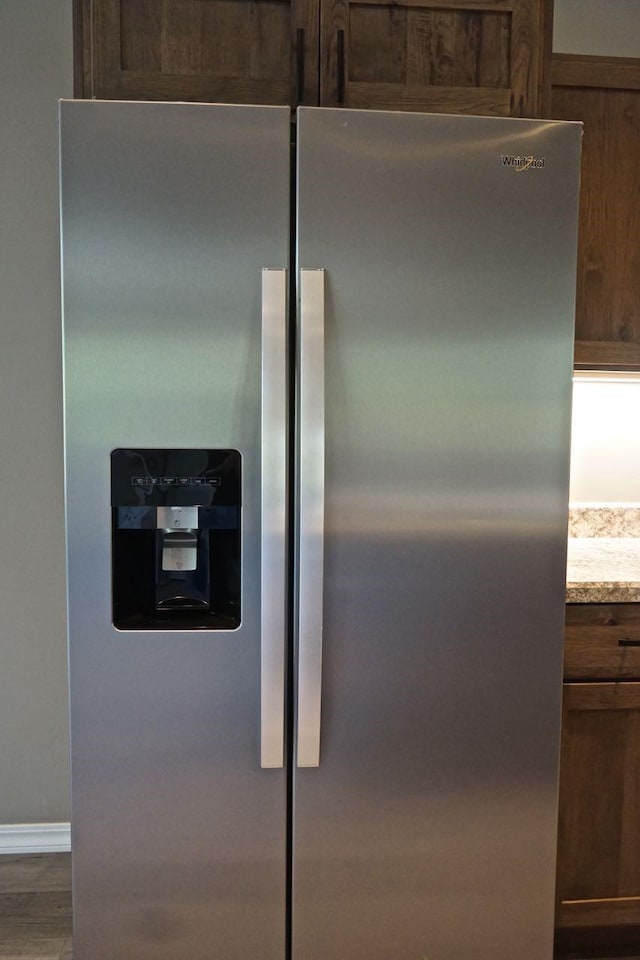 interior details with stainless steel refrigerator with ice dispenser and wood finished floors