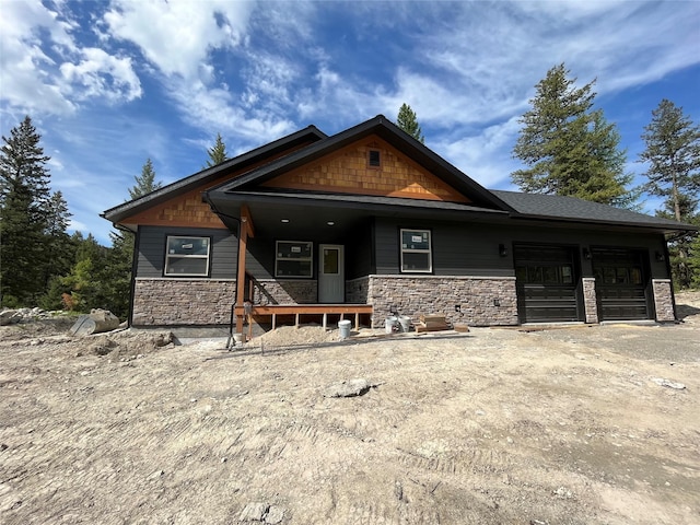 craftsman-style home with driveway, stone siding, and a garage