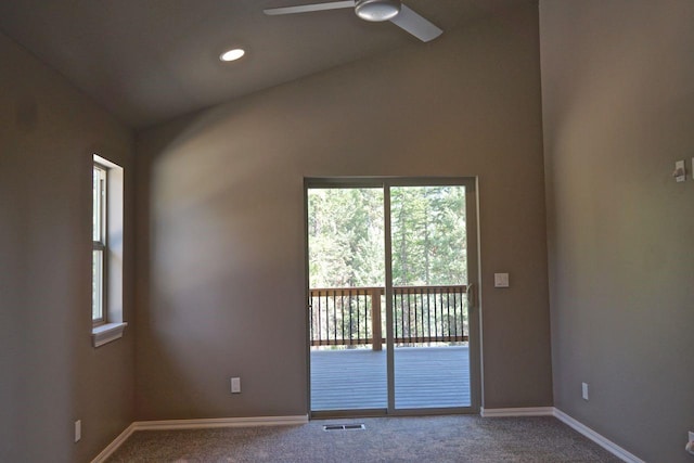 empty room with carpet floors, visible vents, vaulted ceiling, ceiling fan, and baseboards