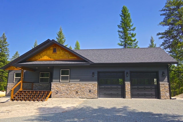 craftsman-style home with a garage, stone siding, and a porch