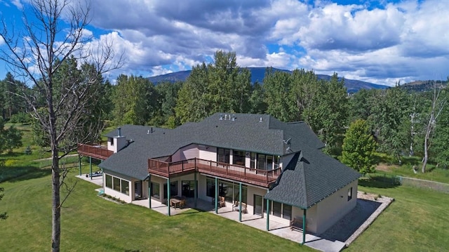 back of property featuring a patio area, a yard, and a deck with mountain view