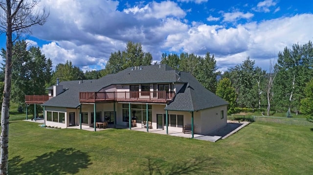 rear view of house with a patio, a wooden deck, and a lawn