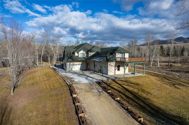 view of front of home with a garage, a front lawn, and a deck