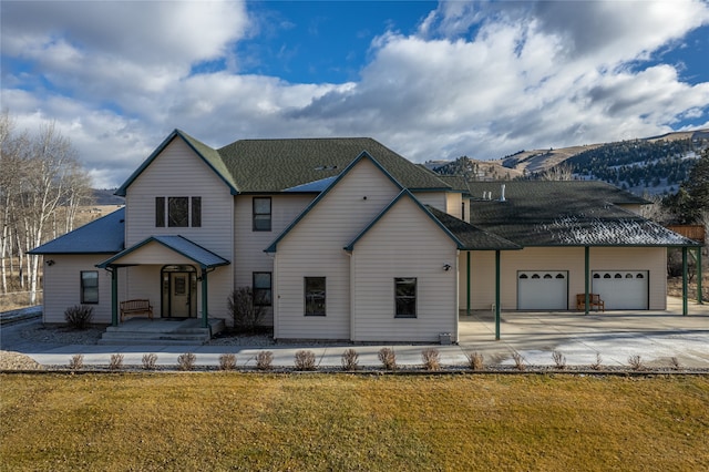 view of front of house with a mountain view, a garage, and a front yard