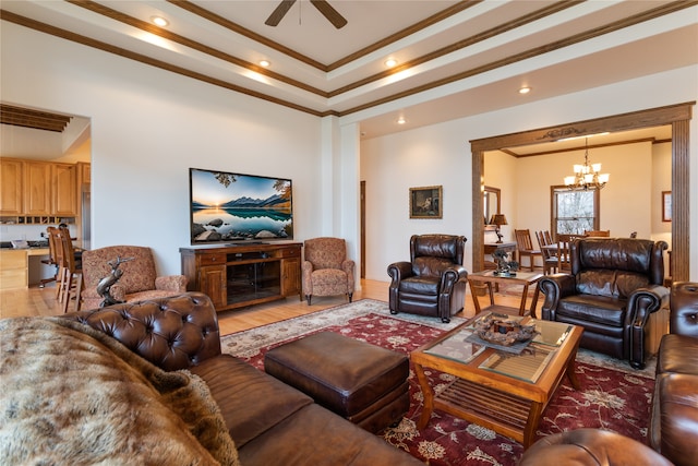 living room with ceiling fan with notable chandelier, hardwood / wood-style flooring, and ornamental molding