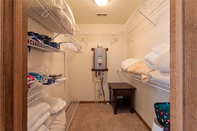 spacious closet with carpet floors and water heater