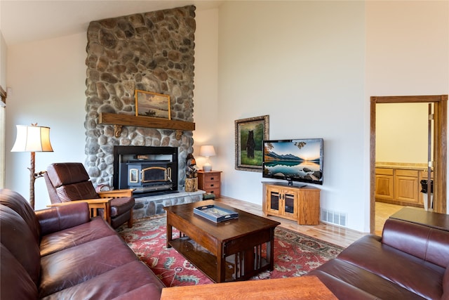 living room featuring hardwood / wood-style flooring, a wood stove, and lofted ceiling