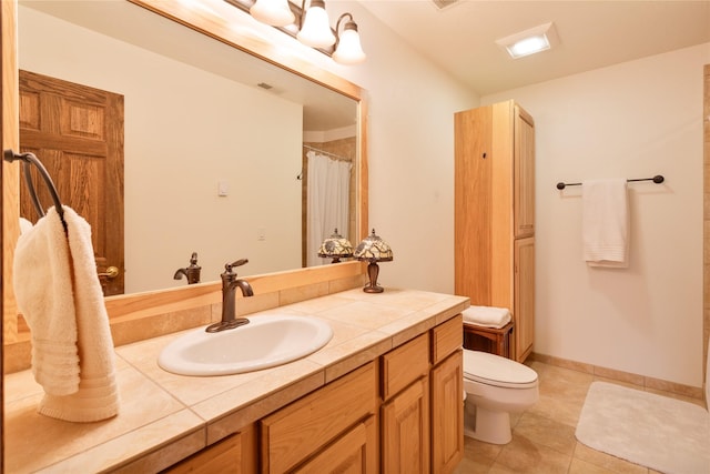 bathroom with tile patterned flooring, vanity, and toilet