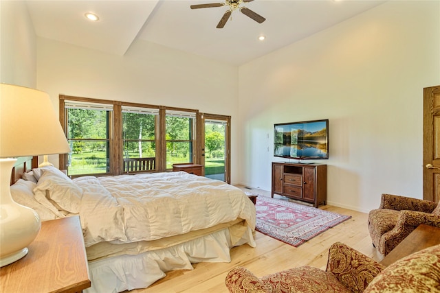 bedroom with ceiling fan, light wood-type flooring, and high vaulted ceiling