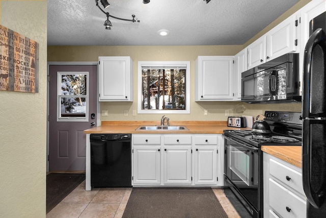 kitchen with black appliances, white cabinets, and sink