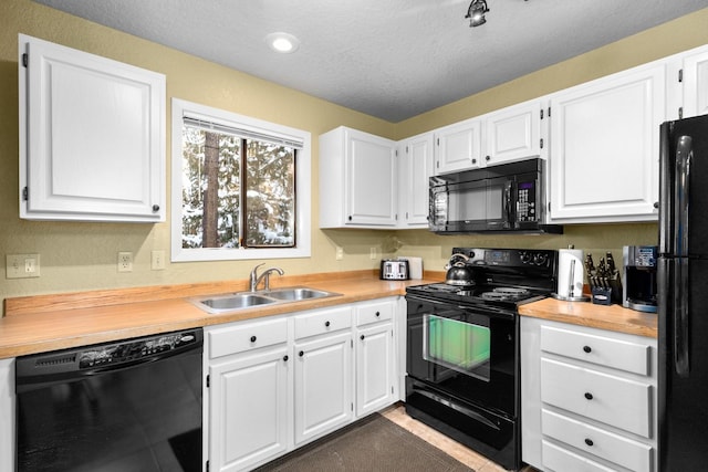 kitchen featuring white cabinets, sink, and black appliances