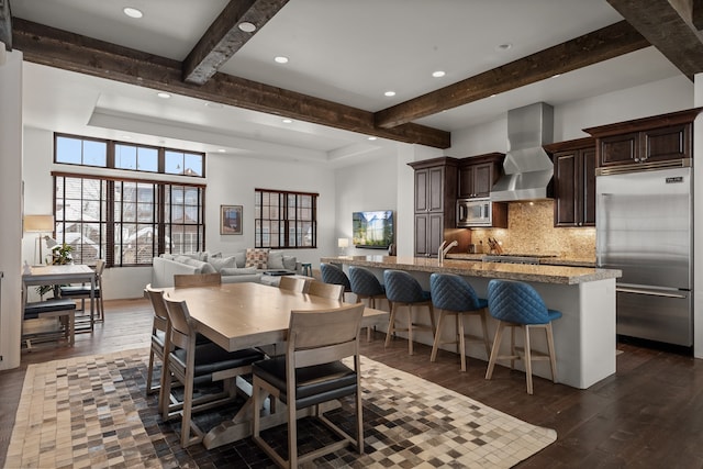 dining space featuring beam ceiling, dark hardwood / wood-style floors, and sink