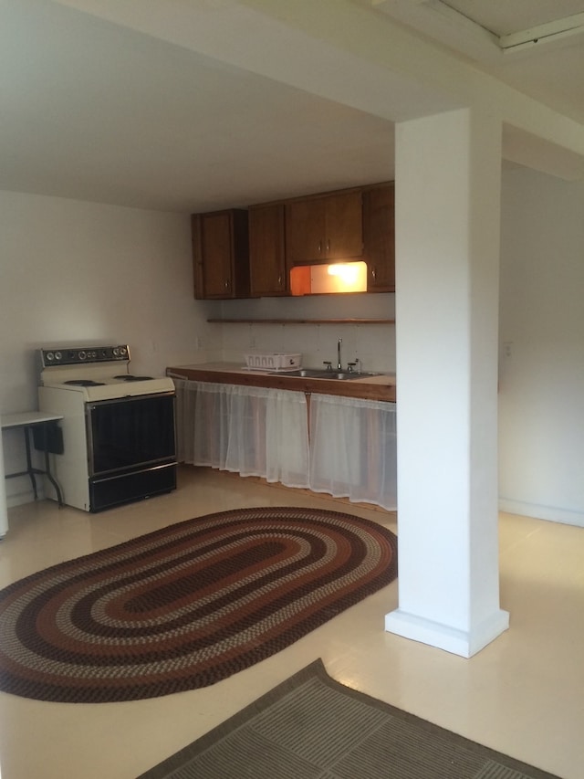 kitchen featuring white electric stove and sink