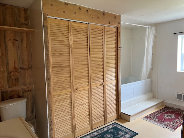 bathroom with toilet and shower / bathtub combination with curtain