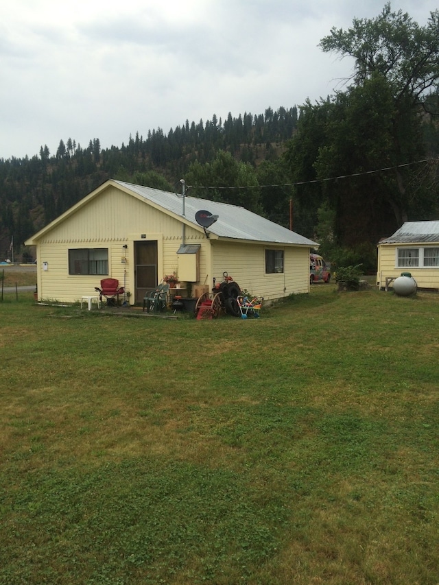 rear view of property with a lawn