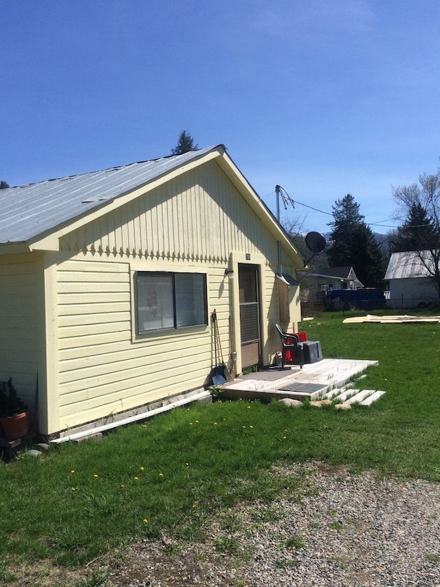 view of side of home with a yard and a patio area