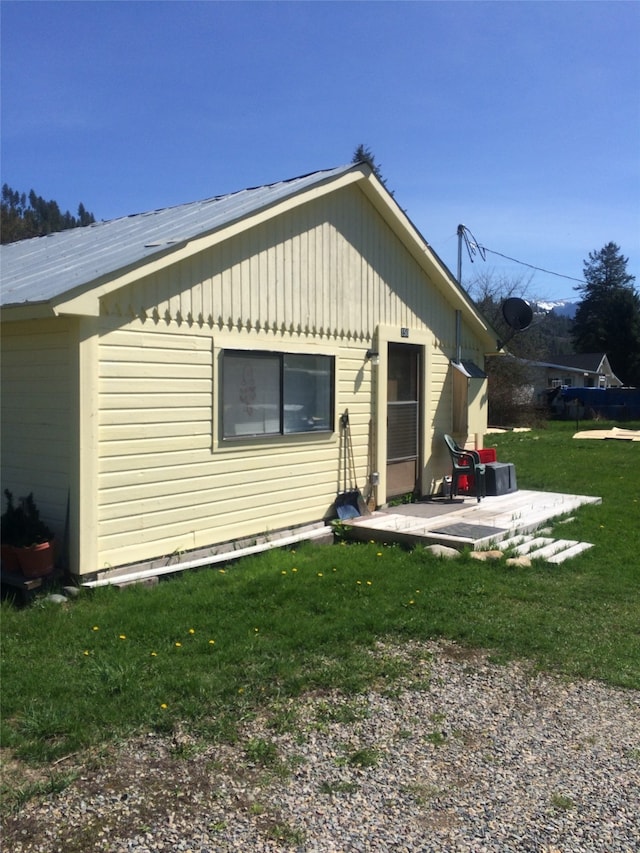 rear view of property featuring a yard and a patio