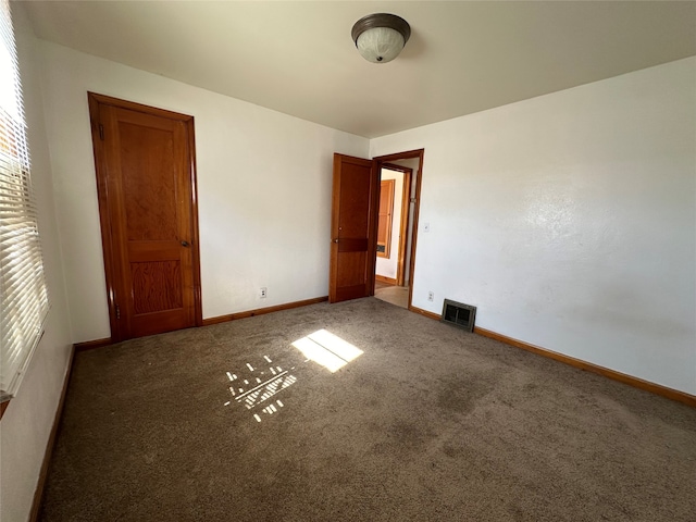 unfurnished bedroom with dark colored carpet