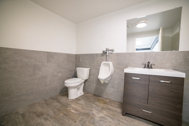 bathroom featuring tile walls, vanity, tile floors, and toilet