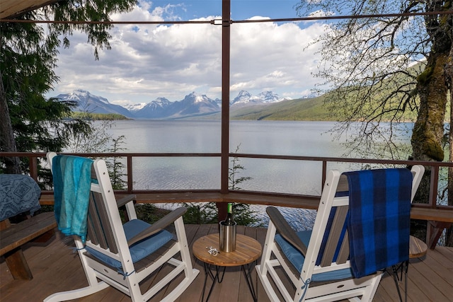 wooden terrace with a water and mountain view