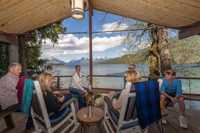 sunroom / solarium featuring wood ceiling, lofted ceiling, a water and mountain view, and plenty of natural light