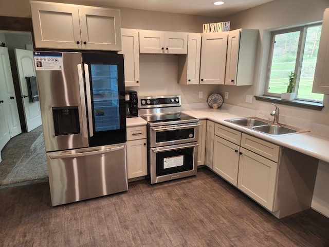 kitchen with sink, dark hardwood / wood-style flooring, white cabinetry, and stainless steel appliances