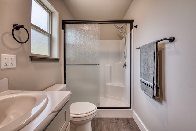 bathroom with walk in shower, vanity, toilet, and hardwood / wood-style flooring