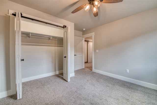 unfurnished bedroom featuring light colored carpet, ceiling fan, and a closet