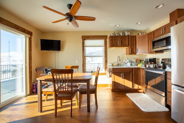 kitchen featuring appliances with stainless steel finishes, sink, wood-type flooring, and ceiling fan