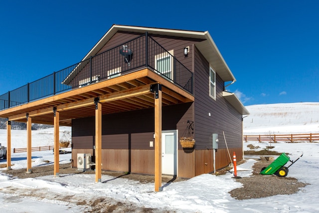 snow covered house featuring a balcony