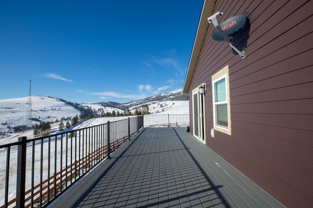 snow covered back of property with a mountain view