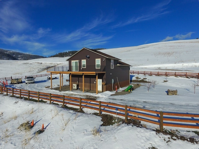 snow covered house with a wooden deck