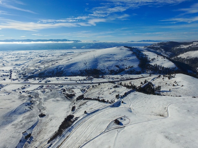 snowy aerial view with a mountain view