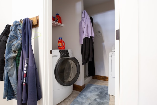 clothes washing area with tile floors and washer / dryer