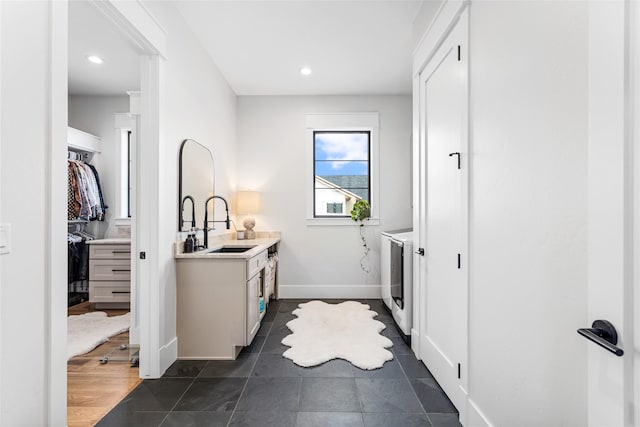 laundry room with sink, dark tile patterned floors, and washing machine and clothes dryer