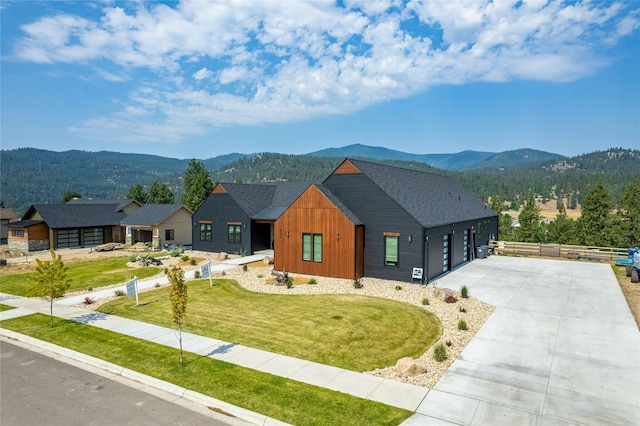 view of front of property with a front yard, a garage, and a mountain view