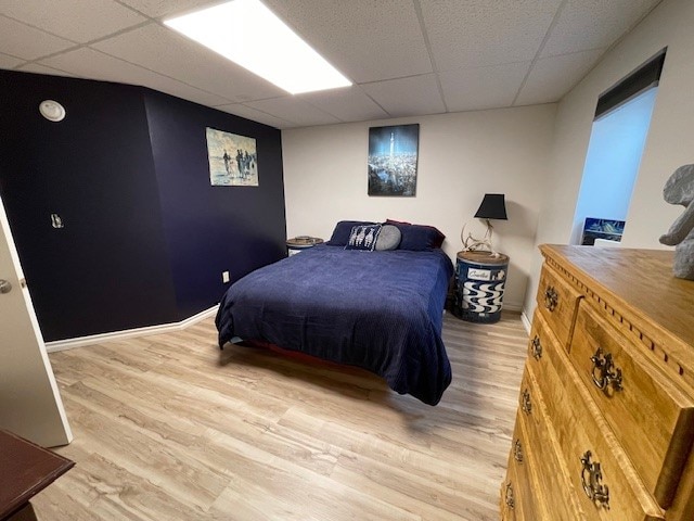 bedroom featuring light hardwood / wood-style floors and a paneled ceiling