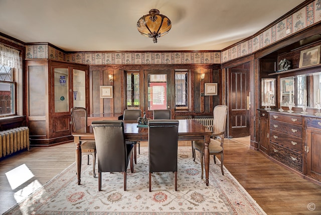 dining space with ornamental molding and light wood-type flooring