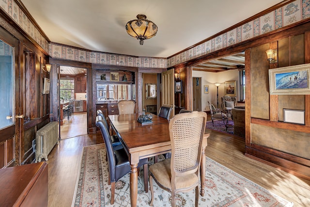 dining area with hardwood / wood-style floors, crown molding, and radiator