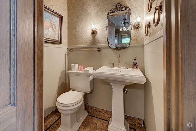 bathroom featuring tile walls, toilet, and tile flooring