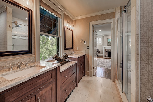 bathroom featuring tile flooring, double vanity, tasteful backsplash, crown molding, and a shower with door