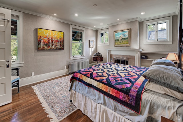 bedroom with ornamental molding, multiple windows, radiator, and dark hardwood / wood-style floors