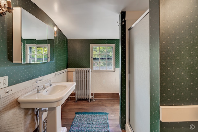 bathroom featuring plenty of natural light, hardwood / wood-style floors, an enclosed shower, and radiator heating unit