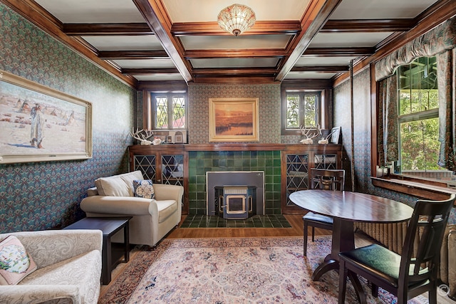 living room featuring beamed ceiling, a wood stove, hardwood / wood-style flooring, and coffered ceiling