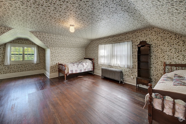 unfurnished bedroom featuring vaulted ceiling, dark hardwood / wood-style flooring, and radiator