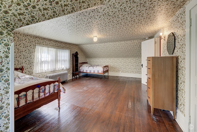 bedroom with lofted ceiling, dark hardwood / wood-style flooring, a textured ceiling, and radiator heating unit