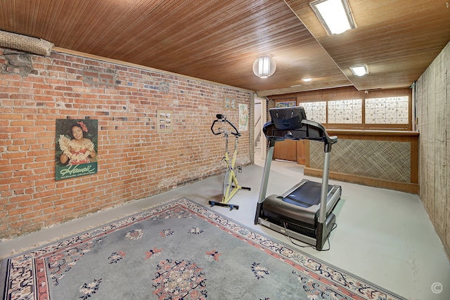 workout area with wooden ceiling, brick wall, concrete flooring, and wooden walls