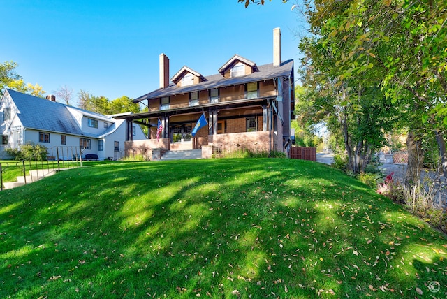 rear view of house featuring a lawn