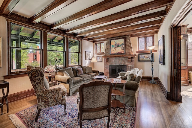 living room featuring a healthy amount of sunlight, a fireplace, wood-type flooring, and beam ceiling