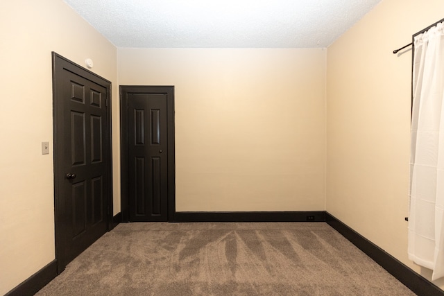 spare room featuring a textured ceiling and carpet flooring